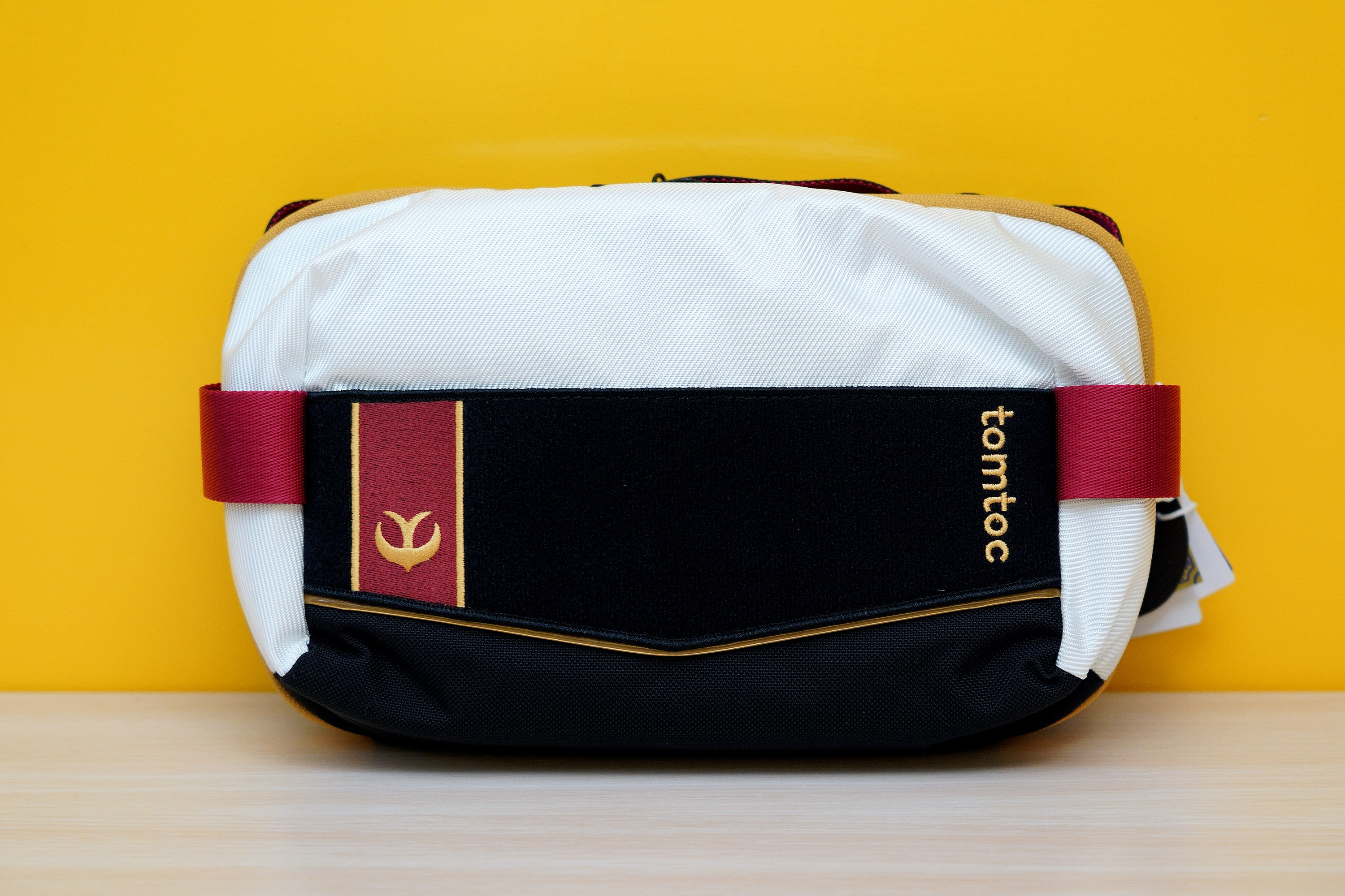 延續「王國騎士」系列防具的黑白紅配色風格,尺寸比 S 號斜肩包稍大一些,沒有背帶但有提帶 image