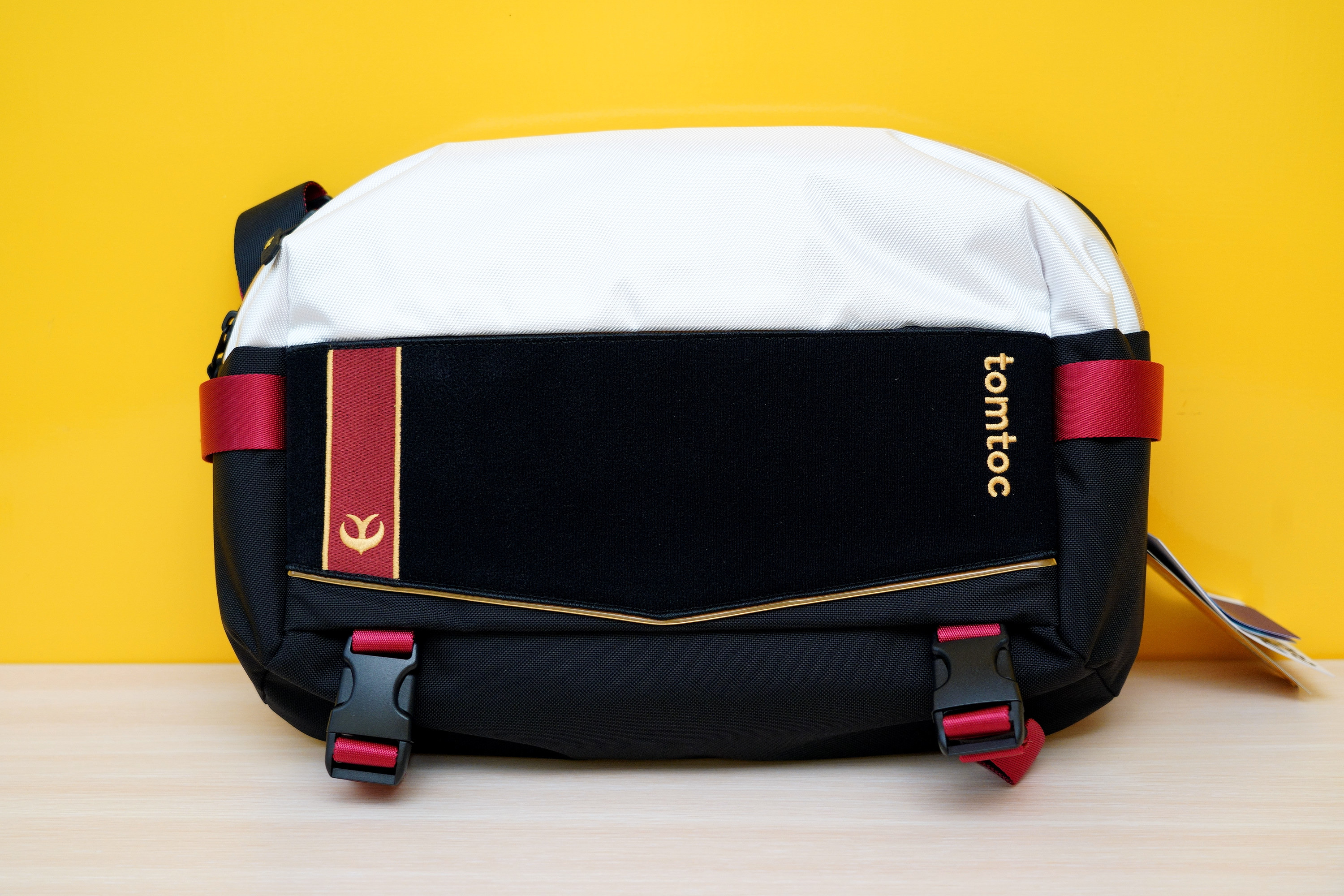 前面一長條是可以黏貼魔鬼氈的絨布,能搭配專屬的刺繡布章。底下設計有可以收納折傘(或腳架等)的扣帶 image