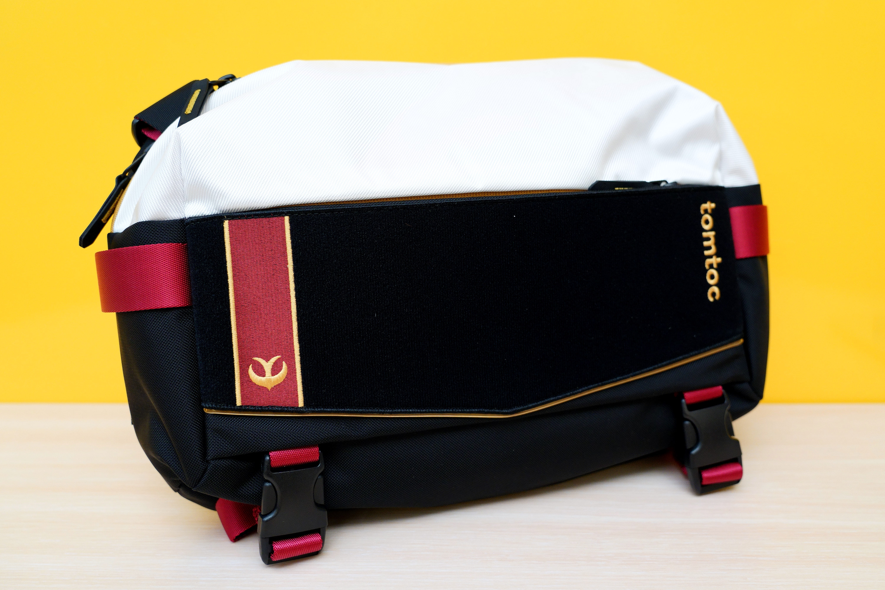 前面一長條是可以黏貼魔鬼氈的絨布,能搭配專屬的刺繡布章。底下設計有可以收納折傘(或腳架等)的扣帶 image