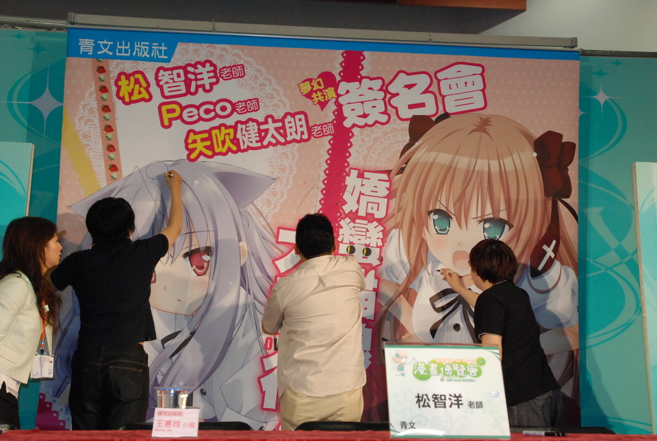 三位老師在活動大海報上簽名留念