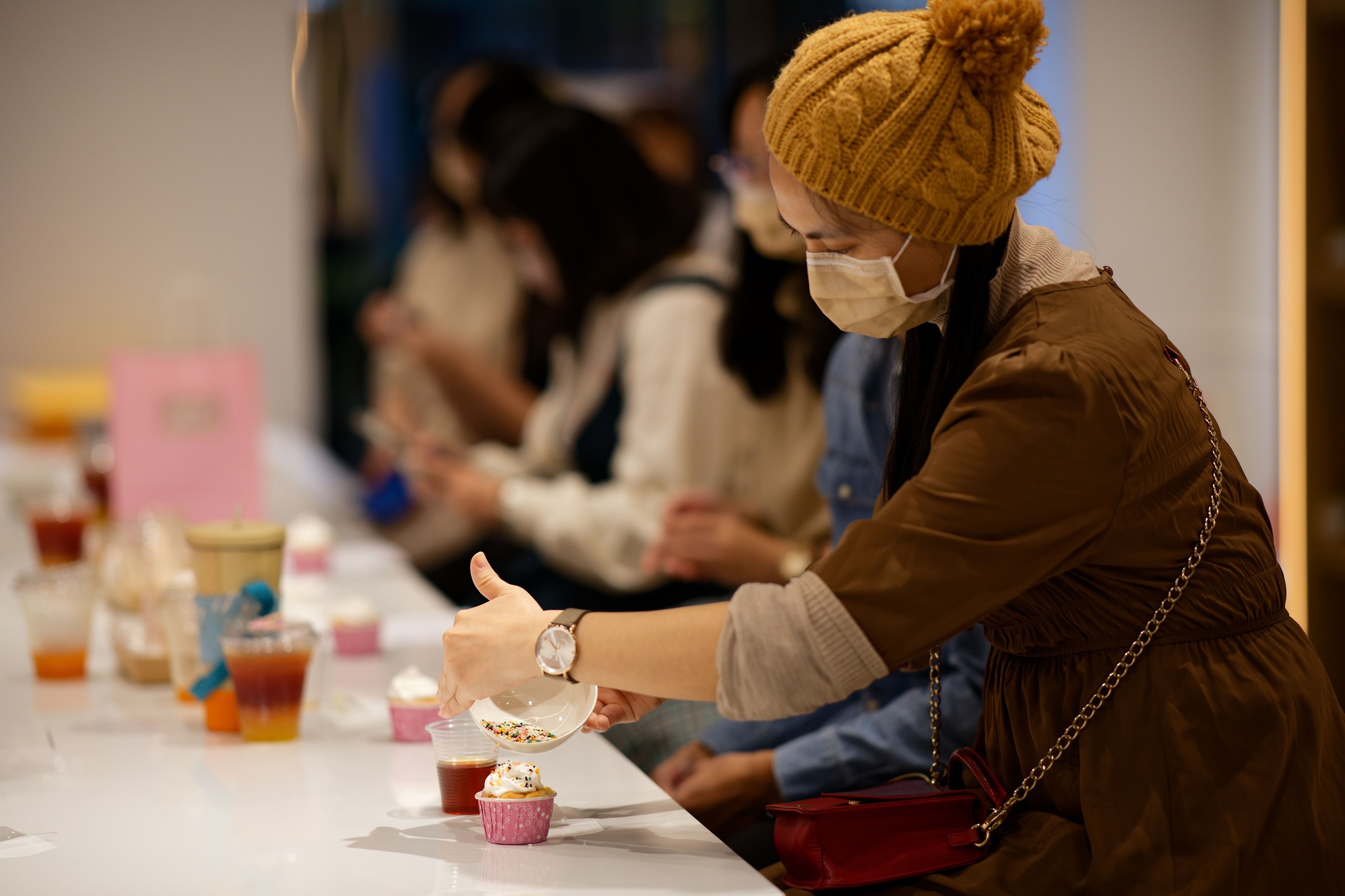 搭配師們認真裝飾獨一無二的杯子蛋糕 image