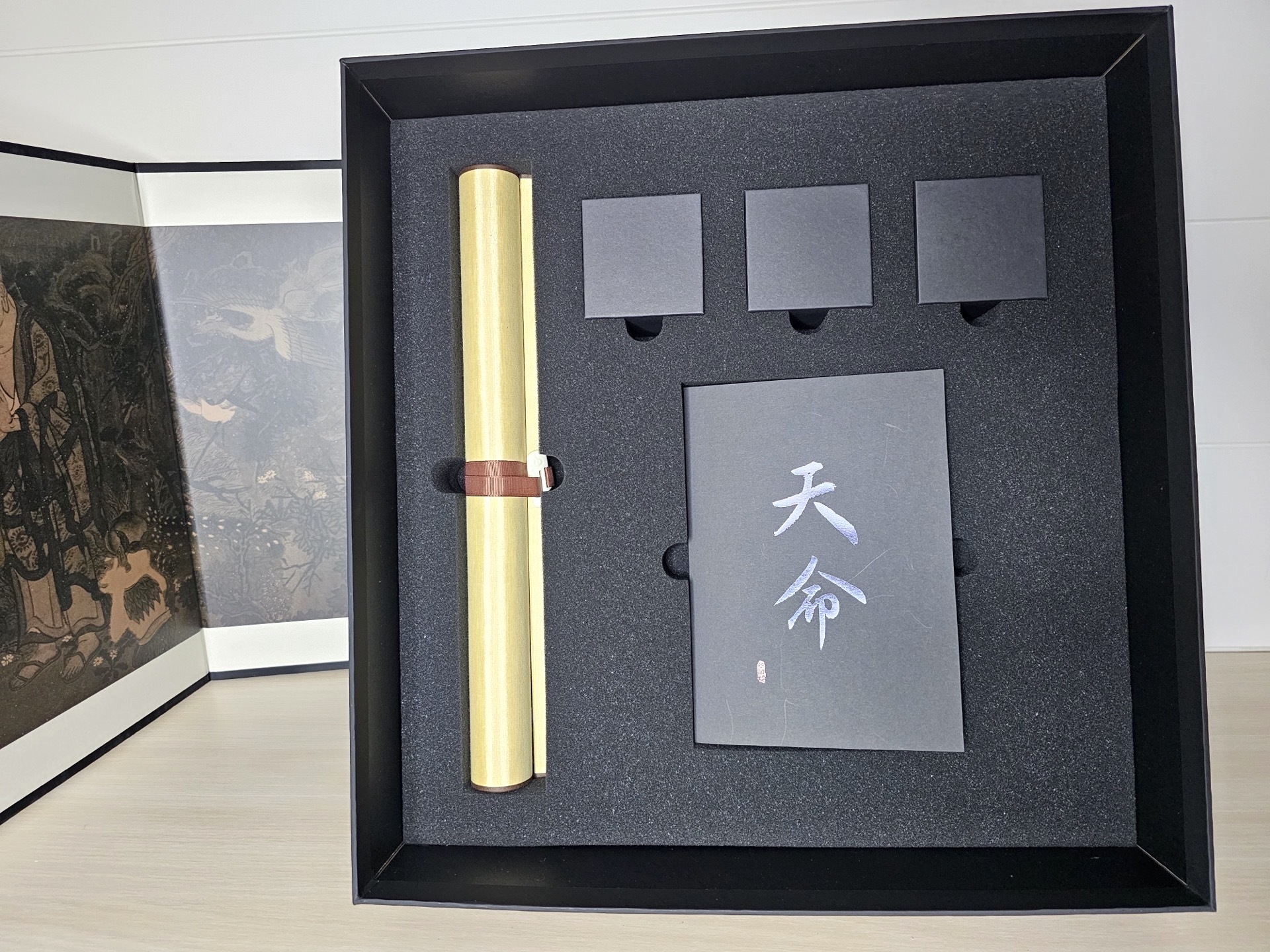 第三層則收納了各式周邊,包括中國郵票、金烏徽章、雷榍戒指與鳳鐸項鍊,還有 “受心經” 畫卷 image