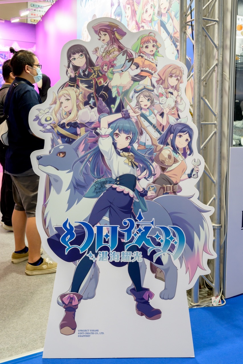 Happinet 攤位前展示著由夜羽聲優小林愛香、梨子聲優逢田梨香子親筆簽名的立牌 image