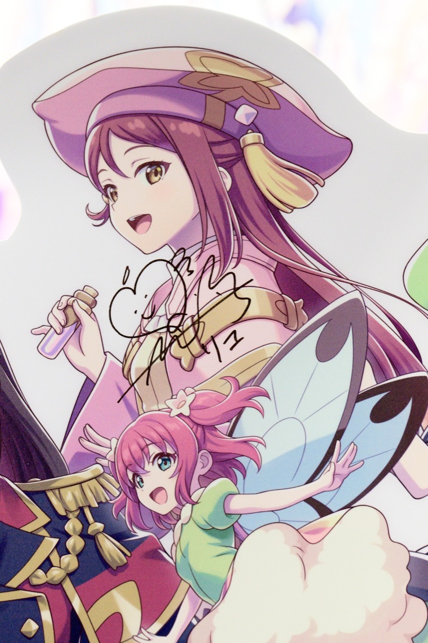 Happinet 攤位前展示著由夜羽聲優小林愛香、梨子聲優逢田梨香子親筆簽名的立牌 image